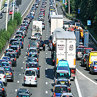 Auto's in de file tijdens druk verkeer op autosnelweg tijdens de vakantie in de zomer gezien door vergrootglas tegen verlichte wereldbol
